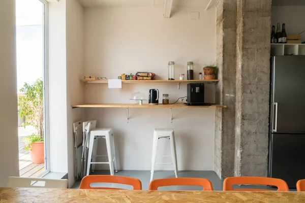 Small kitchen coffee space in an office with empty seats and tables.