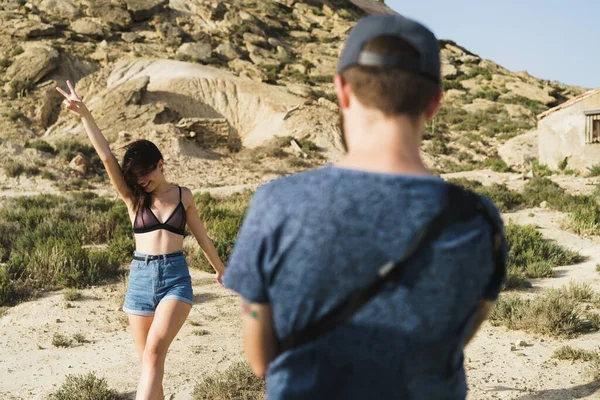 砂漠の風景の中で若い女性の写真を撮る無名の男 ロイヤリティフリーのストック写真
