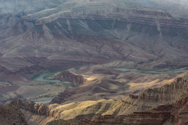 Büyük Kanyon, gün batımında nefes kesici bir manzaraya sahiptir. Kaya tabakalarının zengin tonlarını vurgular..
