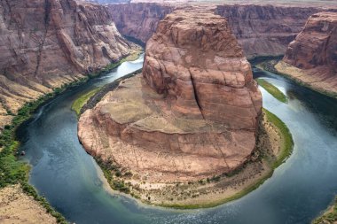 Sakin bir öğleden sonra yakalanan Colorado Nehri Arizona 'daki Horseshoe Bend' in dramatik kaya oluşumları etrafında zarifçe kıvrılarak doğanın çarpıcı güzelliğini gözler önüne seriyor..