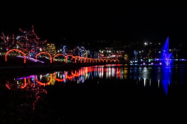 Göz kamaştırıcı bir ışık demeti gece bir parkı aydınlatıyor ve suda büyüleyici yansımalar yaratıyor. Festival dekorasyonları ziyaretçileri büyülü atmosfere hayran bırakıyor..
