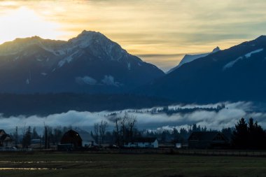 Soluk kesici bir manzara, sabah erken saatlerde parlayan karlı dağları, vadinin üzerinde sürüklenen sisleri, aşağıda yuva yapmış sakin çiftlik evleriyle tamamlıyor..