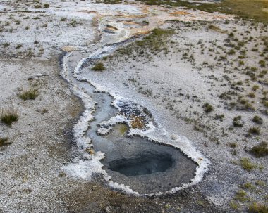 Jeotermal aktivite Yellowstone Ulusal Parkı 'nda temiz mavi sularla dolu çarpıcı bir havuz oluşturuyor. Havuzun etrafında mineraller ve toprak tonlardan yükselen buhar doğanın güzelliğini gözler önüne seriyor..
