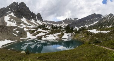 Göz kamaştırıcı dağ manzarası, kayalık zirveler ve kar parçalarıyla çevrili kristal berraklığında bir göle sahiptir. Bereketli yeşillik yaz manzarasına canlılık katar, keşif ve rahatlamaya davetiye çıkarır..