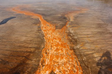 Parlak turuncu mineral yatakları Wyoming 'deki bir milli parktaki jeotermal alanda doğal güzelliği ve jeotermal aktiviteyi gösteren karmaşık desenler oluşturur..