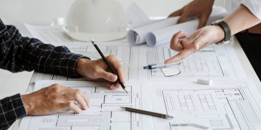 close up of team engineer or architect meeting for project working with partner and engineering tools on model building and blueprint in working site. Construction concept