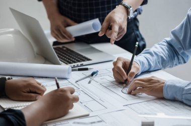 close up of team engineer or architect meeting for project working with partner and engineering tools on model building and blueprint in working site. Construction concept