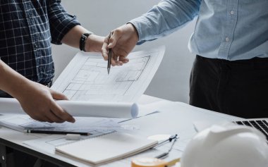 close up of team engineer or architect meeting for project working with partner and engineering tools on model building and blueprint in working site. Construction concept