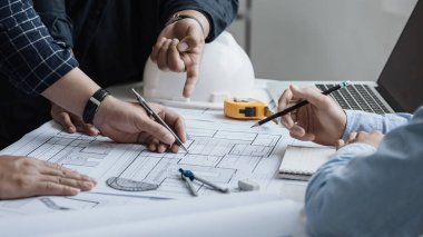 close up of team engineer or architect meeting for project working with partner and engineering tools on model building and blueprint in working site. Construction concept