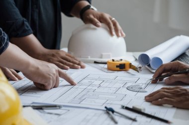 close up of team engineer or architect meeting for project working with partner and engineering tools on model building and blueprint in working site. Construction concept