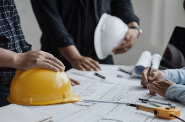 close up of team engineer or architect meeting for project working with partner and engineering tools on model building and blueprint in working site. Construction concept