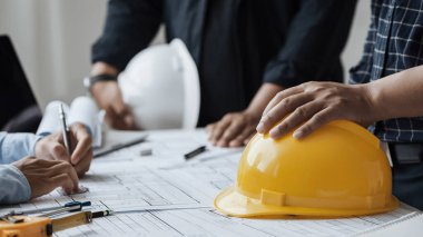 close up of team engineer or architect meeting for project working with partner and engineering tools on model building and blueprint in working site. Construction concept