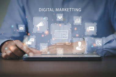 Marketer using a tablet to analyze digital online marketing and web icon for business and social media marketing, content marketing, viral, SEO, keyword, advertise, website, and internet marketing.