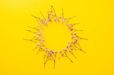 Sarı arka planda mor çiçekler, daire şeklinde düzenlenmiş, çerçeve oluşturulmuş, yaz arkaplanı.