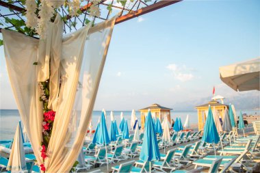 Kapalı beyaz şemsiyeli mavi şezlonglu plaj kulübü, deniz, plaj.