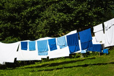 Havlular ve çarşaflar dışarıda ve kuru, orman ve doğa ile çevrili.