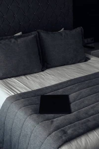 Bir Dizüstü Bilgisayar Gri Çarşaflı Bir Yatakta Yatıyor — Stok fotoğraf