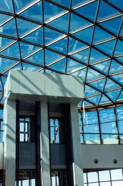 Modern bir asansör, vitray pencerelerin arka planında bir model oluşturuyor.