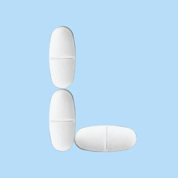 Písmeno Vyloženo Pilulkami Modrém Pozadí — Stock fotografie