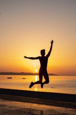 Kız gün doğumunda spor yapıyor.