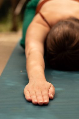 Ellerinizi yoga minderinin üzerine koyun, dinlenme pozisyonu ve esneme pozisyonu, kız spor ve somatik egzersizlerle meşgul.