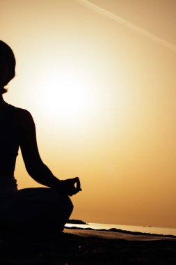 Gün batımında yoga ya da pilates yapan genç bir kadın silueti ya da güzel bir dağ yerinde güneşin doğuşu. Beden ve zihin rahatlığı için fiziksel aktivite, sağlıklı yaşam tarzı alışkanlıkları kavramı 