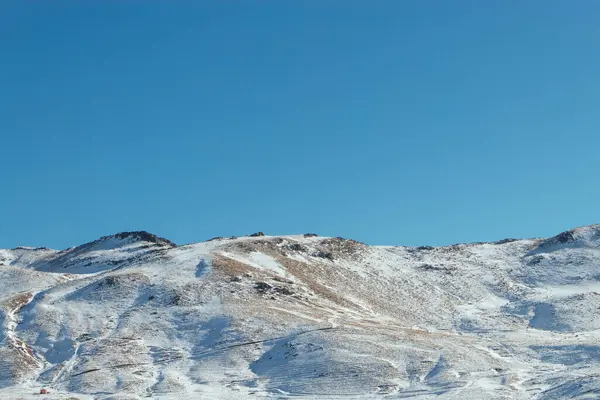 stock image The first snow in the mountains, Stratovolcano, Ergyes, Turkey, partially snow-covered hills against a clear blue sky