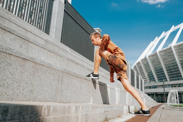 young man training outdoors, first training outdoors, the student is engaged in physical education on the street, the first training