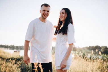 Gün batımında el ele tutuşan genç bir çift.