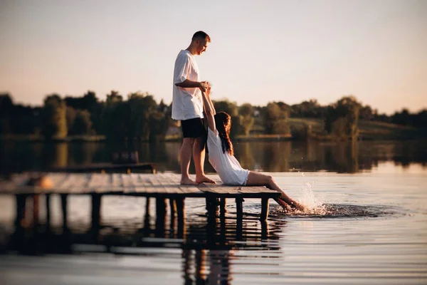 Bir Adam Gün Batımında Nehrin Kenarında Oturan Bir Kızın Elini — Stok fotoğraf