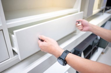 Erkek el çekme ve beyaz ahşap dolaptaki çekmeceyi açma. Ev eşyaları ve dekorasyon alışveriş konsepti