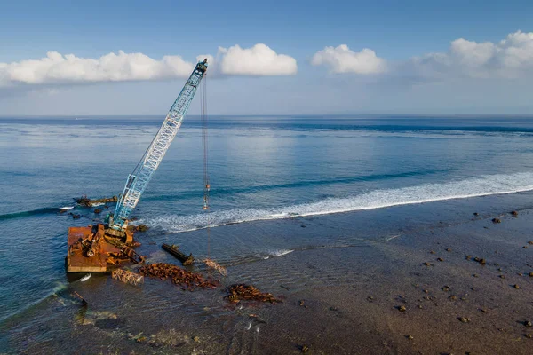 印度尼西亚巴厘岛附近的努沙伦邦海滩附近海面上废弃建筑起重机的空中景观 — 图库照片
