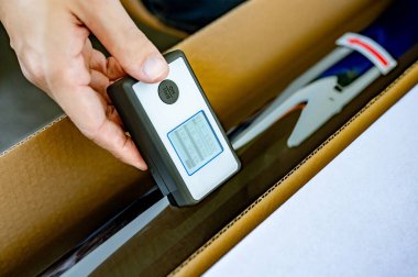 Erkek otomobil uzmanı el, araba vitrininde vites göstergesi kullanarak güneş ışığı koruma verimliliğini kontrol ediyor.