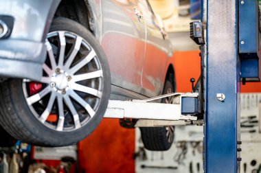 Garaj atölyesinde ya da oto tamirhanesinde hidrolik asansörde araba. Araba süspansiyonunu kontrol etmek ya da lastik değiştirmek için araç kaldırmak