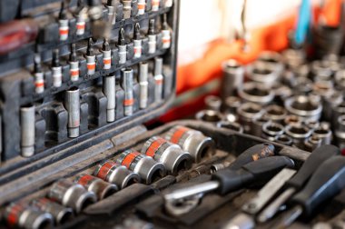 Bir kutu tornavida parçalarını ısırdı ve tamirhanedeki veya tamirhanedeki tezgahta soket anahtarı kullandı. Araba tamiri ve bakımı için otomatik mekanik aracı