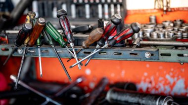 Bir grup tornavida ve diğer mekanik çalışma araçları garaj atölyesinde çalışma tezgahında