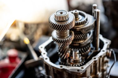 Parçalanmış araba otomatik vites parçası ya da oto tamir atölyesindeki tezgahta vites kutusu. Tamir ve bakım araçlarının bir kısmı garajda. Makine mühendisliği ve otomotiv endüstrisi