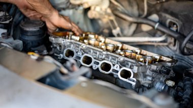 Otomobil tamircisi erkek. Araba tamir atölyesi veya garaj atölyesinde motor parçalarını kontrol ediyor. Araba tamiri ve bakım servisi. Otomobil mühendisliği endüstrisi