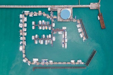 Phuket, Tayland 'daki Chalong İskelesi' nin insansız hava aracı görüntüsü. Andaman Denizi 'nin etrafındaki merkezlerden biri olan Ao Chalong Körfezi rıhtımına demirlemiş pek çok tekne, yat ve sürat teknesi var..