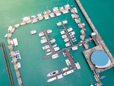 Phuket, Tayland 'daki Chalong İskelesi' nin insansız hava aracı görüntüsü. Andaman Denizi 'nin etrafındaki merkezlerden biri olan Ao Chalong Körfezi rıhtımına demirlemiş pek çok tekne, yat ve sürat teknesi var..
