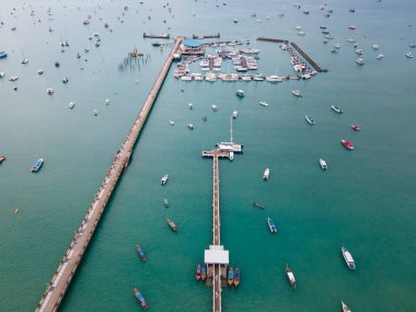 Phuket, Tayland 'daki Chalong İskelesi' nin insansız hava aracı görüntüsü. Birçok tekne, yat ve sürat teknesi iskeleye demirlemiş ve Andaman Denizi 'ni dolaşmaya başlamak için Ao Chalong Körfezi' ne demirlemiş..