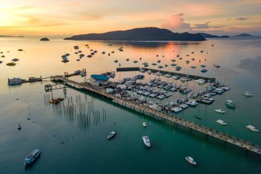 Phuket, Tayland 'da güneş doğarken Chalong İskelesi' nin insansız hava aracı görüntüsü. Birçok yat, katamaran ve sürat tekneleri Andaman Denizi 'nin etrafındaki merkezlerden biri olan Ao Chalong Körfezi rıhtımına demirlemişti..