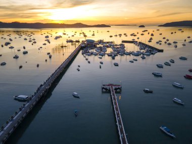 Phuket, Tayland 'da güneş doğarken Chalong İskelesi' nin insansız hava aracı görüntüsü. Birçok yat, katamaran ve sürat tekneleri Andaman Denizi 'nin etrafındaki merkezlerden biri olan Ao Chalong Körfezi rıhtımına demirlemişti..