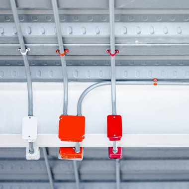 Modern binanın tavanında renkli elektrik kabloları için elektrik bağlantı kutusu olan elektrik kablosu kanalı. Güç sistemleri için boru ve montaj ekipmanları