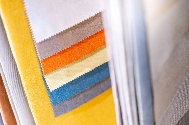 Renkli kumaş kumaş kumaş koleksiyonu. Ev dekorasyon mağazasında çeşitli renk ve doku örnekleri var. Mobilya bitirme veya giysi tasarımı için tekstil endüstrisi