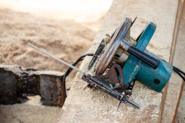 Kereste yığınında elektrikli testere. Ahşap tahta kesmek için kullanılan bir atölyede marangozluk aleti. Kereste endüstrisi konsepti