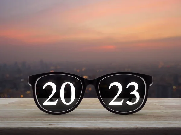2023 White Text Black Eye Glasses Wooden Table Blur Cityscape — Stock Photo, Image