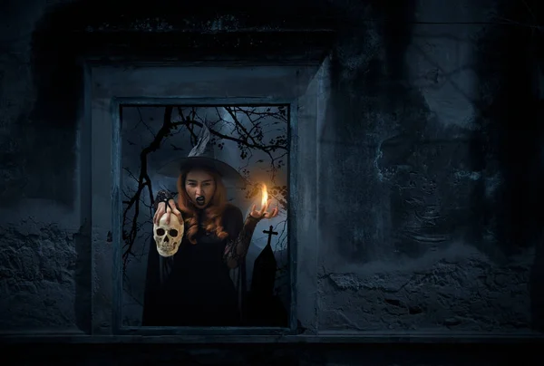 Halloweenská Čarodějnice Držící Lebku Starém Poškozeném Okně Zdí Nad Křížem — Stock fotografie