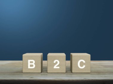 Tahta küpler üzerinde B2C harfi açık mavi duvar üzerinde ahşap masa, müşteri pazarlama ve strateji konsepti iş