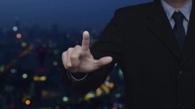 Businessman pressing 2023 start up business flat icon over blur colorful night light modern city tower and skyscraper, Business happy new year 2023 cover concept
